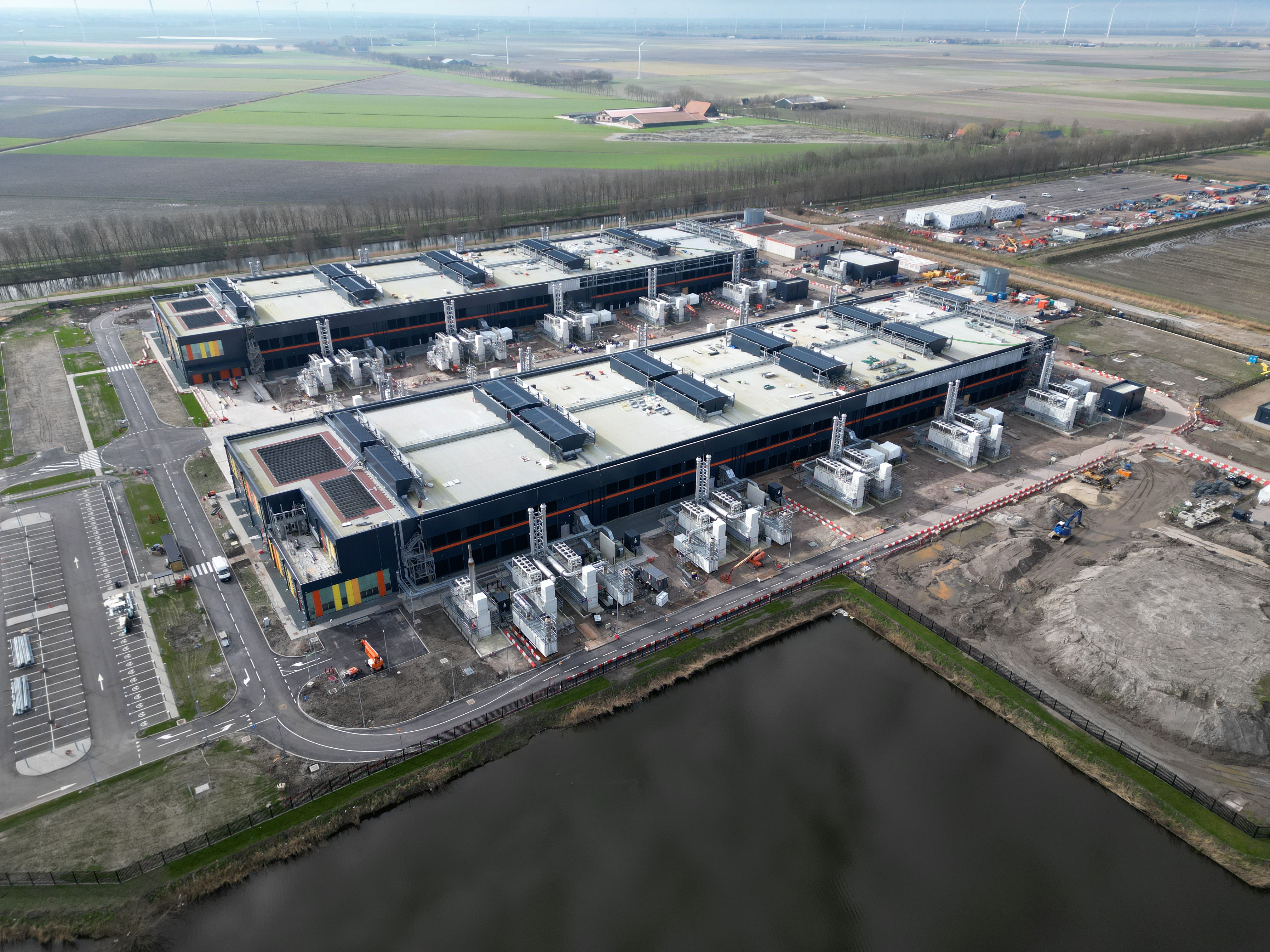 Large warehouses used for data centres next to a large body of water.